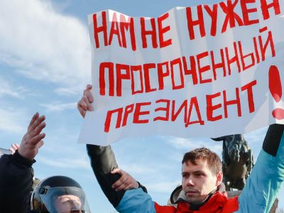 Демонстрант в Санкт-Петербурге держит плакат с надписью: "Нам не нужен просроченный президент!". Фото: PETER KOVALEV/TASS