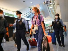 Кристину Тимановскую сопровождают сотрудники полиции в международном аэропорту Ханэда в Токио, Япония, 1 августа 2021 года. Фото: Issei Kato / REUTERS